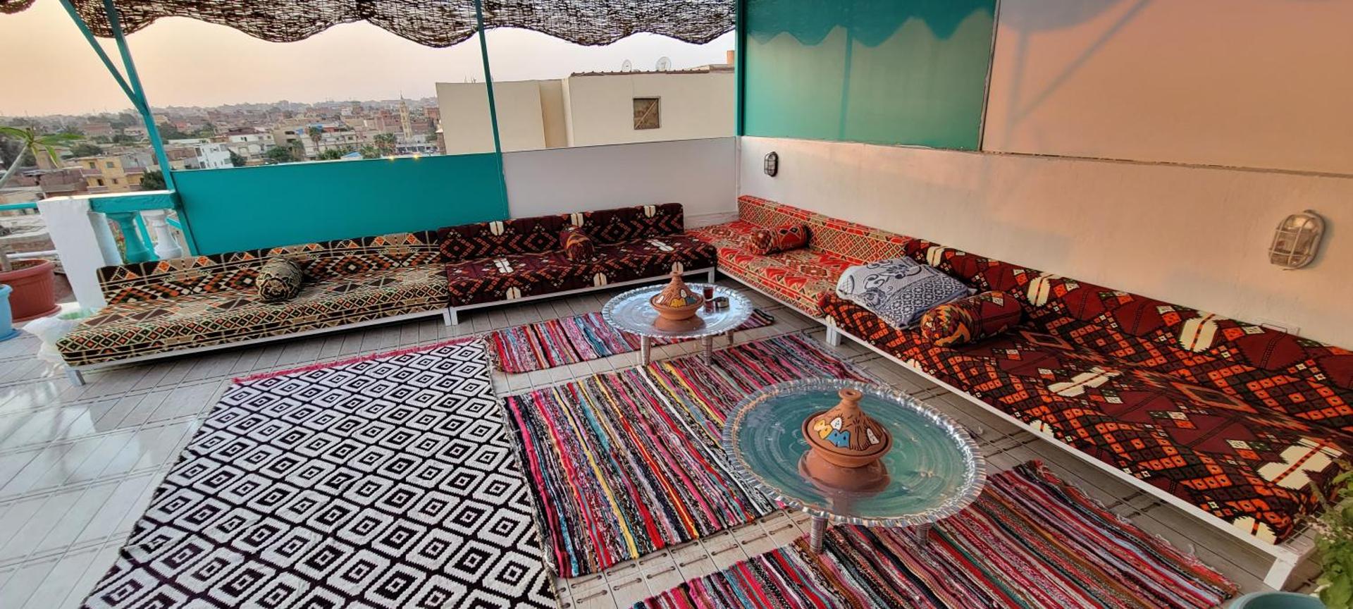Rooftop lounge with rugs, floor cushions and a brass tray